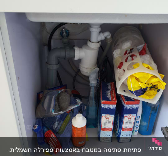 צנרת מתחת לכיור עם מוצרי ניקוי